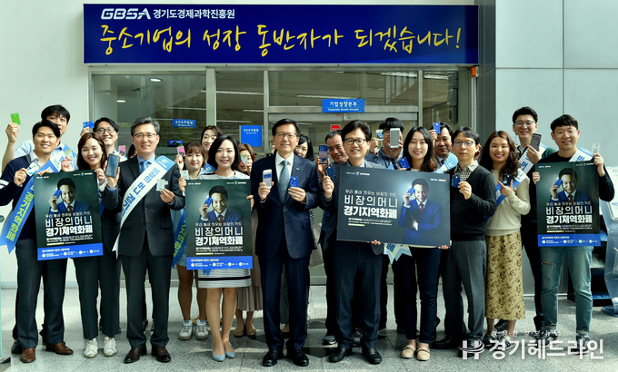 24일 경과원 로비에서 김기준 원장을 비롯한 임직원들이 경기지역화폐와 홍보물을 들고 기념촬영을 하고 있다.