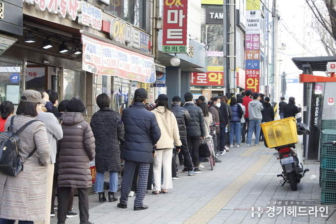 수원시 한 약국에서 마스크 구입을 위해 시민들이 길게 줄을지으며 차례를 기다리고 있다