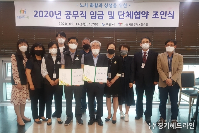 14일 수원시 조진행 행정지원과장(앞줄 왼쪽 다섯번째), 김규동 수원시공무직노동조합 위원장(앞줄 왼쪽 4번째)이 협약식 후 관계자들과 기념촬영을 하고 있다.(사진=수원시)
