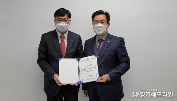  (사)경기언론인협회 박종명 회장이 법무법인 AK 김종수 대표변호사에게 법률고문 위촉장을 전달하고 있다.