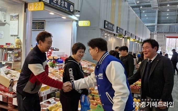 더불어민주당 염태영 수원무 후보는 26일 수원농수산물도매시장 상인들과 악수를 하고 있다.