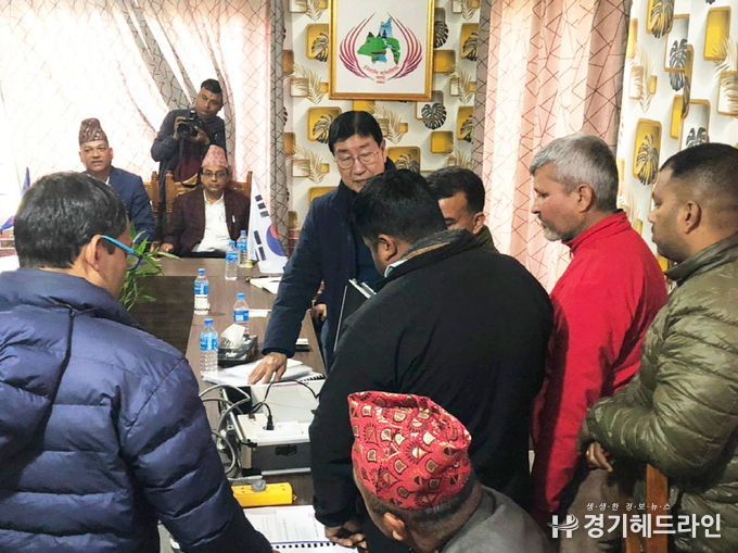 자파시장과 정부관계자와 전기 절감기 시연 및 절감에 대한 설명을 하고 있는 송하준 전무(중앙 안경)