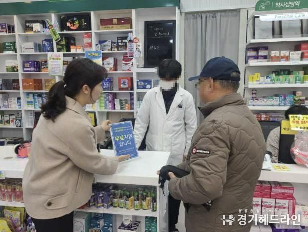 약국에서 방문객에게 치매관리사업을 홍보하고 있다