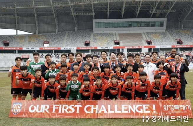 정명근 화성특례시장과 화성FC 선수, 에스코트 키즈들이 K리그2 홈경기 개막전에서 단체사진을 찍고 있다