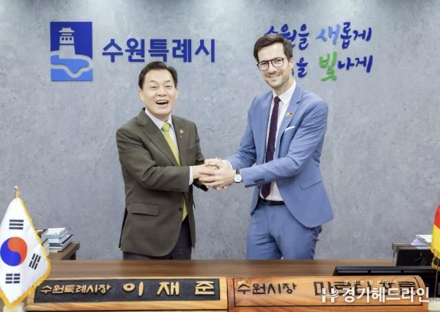 이재준 수원특례시장이 마르틴 호른 프라이부르크시장에게 명예 수원시장 명패를 전달한 후 활짝 웃고 있다.