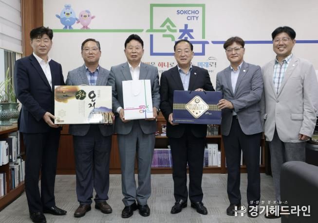 서태원 가평군수(사진 왼쪽 세번째)와 이병선 속초시장(사진 왼쪽 네 번째) 등이 각 지자체 특산품중 하나인 오징어와 막걸리를 교환하고 있다.