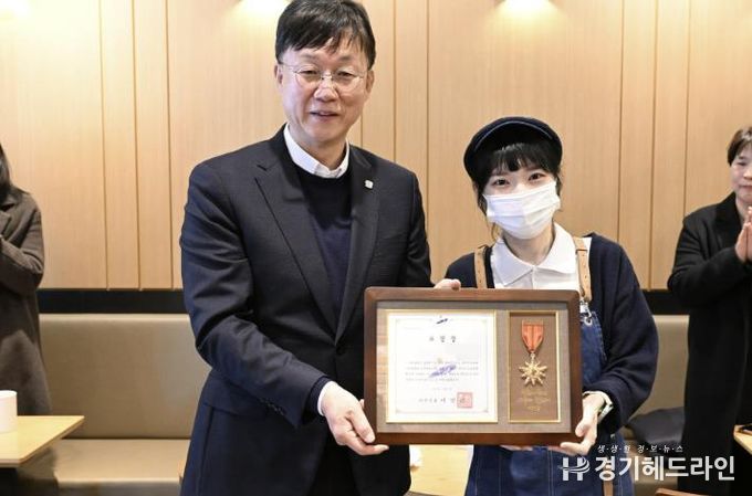 이민근 안산시장(왼쪽)이 지난달 수어로 고객에게 감동 전해 지역 사회에 선한 영향력을 끼친 커피점 점주에게 모범시민 표창을 수여하고 함께 기념촬영을 하고 있다.