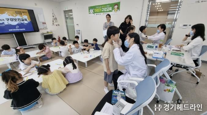 치과의사가 구강검진 및 불소도포를 진행하고 있다.