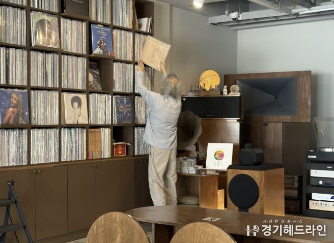 음악감상실 온 주인장이 신청곡 LP를 찾고 있다.